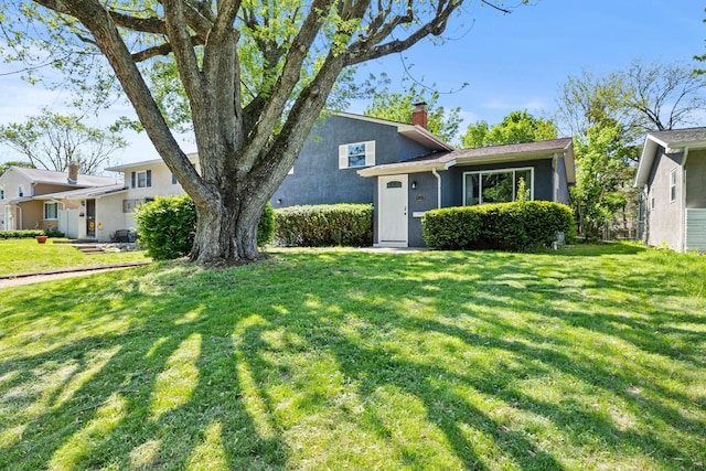 4187 Medway Ave, Columbus, OH 43213 - tri-level home with a chimney, a front yard, and stucco siding