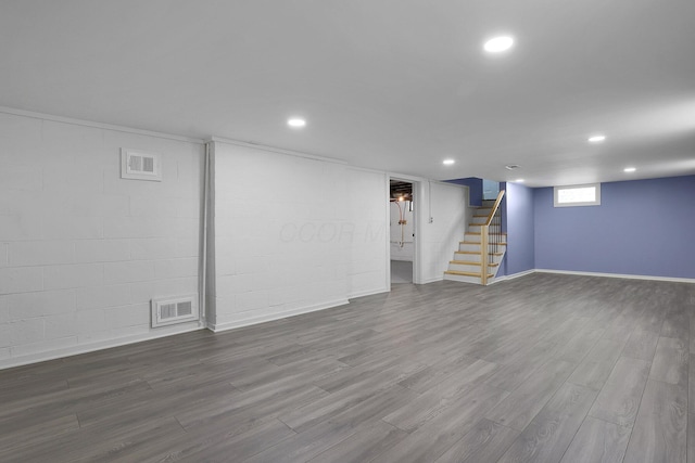 below grade area featuring stairs, dark wood-style floors, recessed lighting, and baseboards