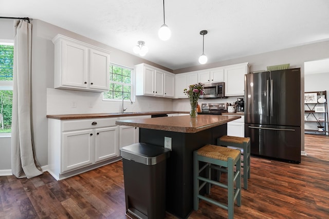 7353 Selma Pike, South Charleston, OH 45368 - kitchen with stainless steel appliances, dark countertops, white cabinetry, and a center island