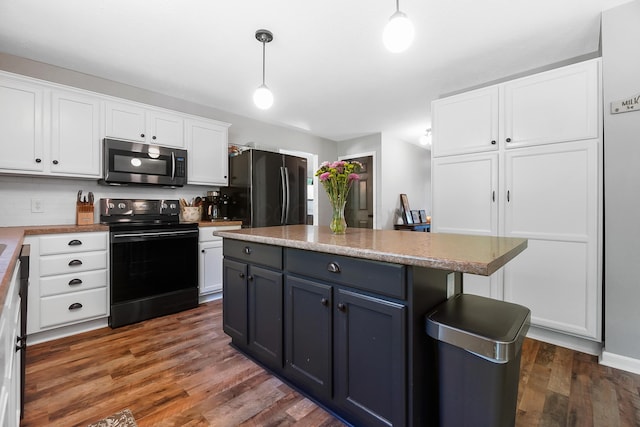 7353 Selma Pike, South Charleston, OH 45368 - kitchen with stainless steel microwave, black range with electric cooktop, freestanding refrigerator, white cabinets, and wood finished floors