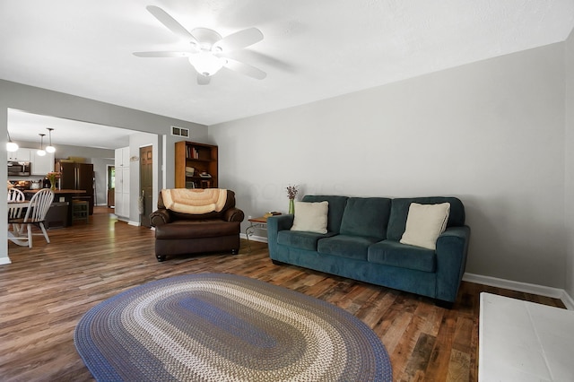 7353 Selma Pike, South Charleston, OH 45368 - living area with dark wood finished floors, baseboards, and a ceiling fan