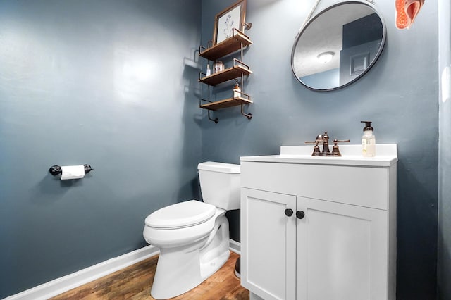 7353 Selma Pike, South Charleston, OH 45368 - half bathroom with baseboards, wood finished floors, toilet, and vanity