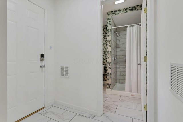 255 E Kelso Rd, Columbus, OH 43202 - bathroom featuring marble look tiles, a stall shower, and baseboards