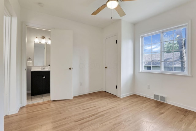 255 E Kelso Rd, Columbus, OH 43202 - unfurnished bedroom with light wood-style floors, baseboards, connected bathroom, and a sink