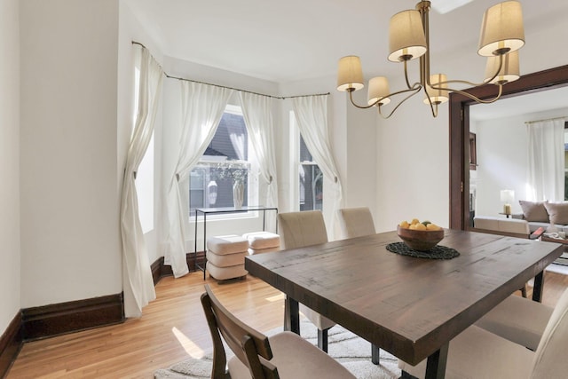 255 E Kelso Rd, Columbus, OH 43202 - dining area with light wood finished floors, a chandelier, and baseboards