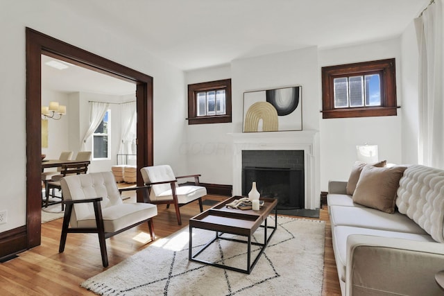 255 E Kelso Rd, Columbus, OH 43202 - living room featuring a chandelier, light wood-style flooring, a fireplace with flush hearth, and baseboards