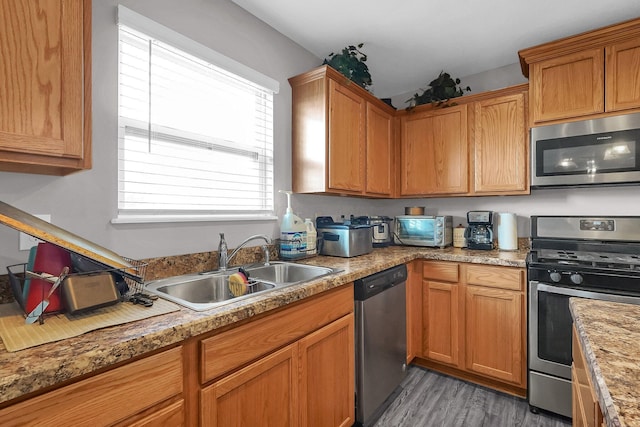 5617 Branchville Dr, Canal Winchester, OH 43110 - kitchen featuring stainless steel appliances, a sink, light wood-style floors, light countertops, and brown cabinetry