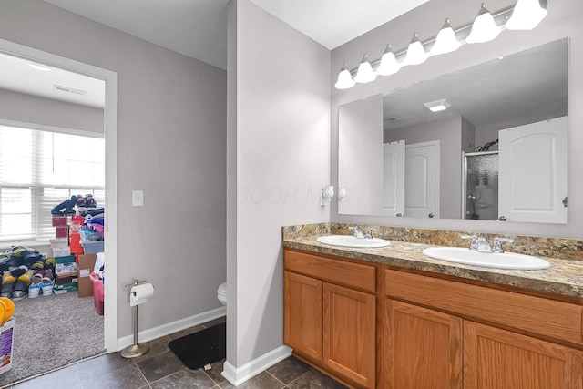 5617 Branchville Dr, Canal Winchester, OH 43110 - full bathroom with a stall shower, double vanity, baseboards, and toilet