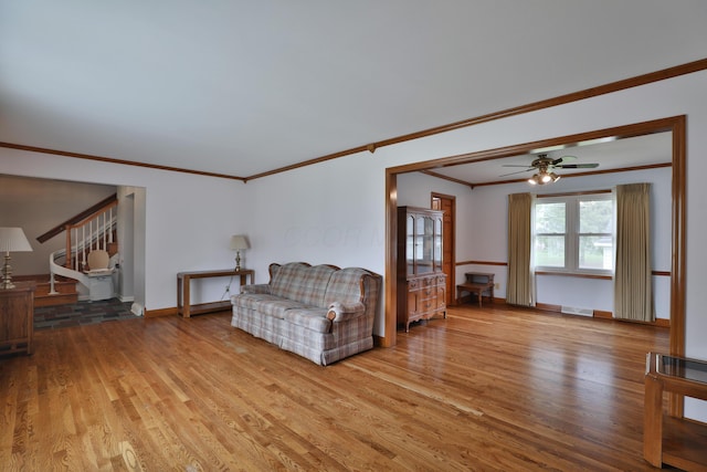 6070 Barberry Holw, Columbus, OH 43213 - living room with light wood-style flooring, ornamental molding, a ceiling fan, stairs, and baseboards