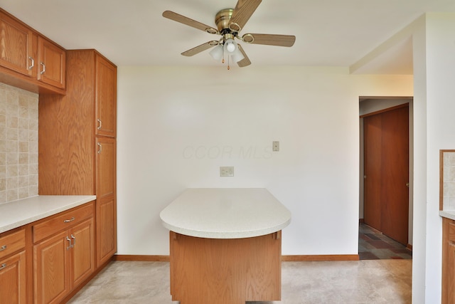 6070 Barberry Holw, Columbus, OH 43213 - kitchen with baseboards, light countertops, brown cabinetry, and ceiling fan