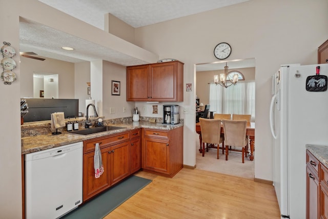 890 Brockwell Dr, Westerville, OH 43081 - kitchen with white appliances, a sink, a chandelier, light wood-type flooring, and brown cabinets