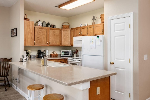 4 Claire Ct, Circleville, OH 43113 - kitchen with white appliances, a sink, a peninsula, a breakfast bar, and light countertops
