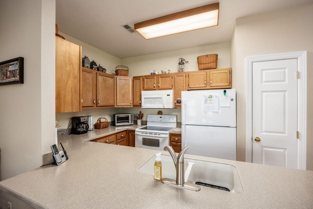 4 Claire Ct, Circleville, OH 43113 - kitchen featuring white appliances, a sink, light countertops, brown cabinetry, and a peninsula