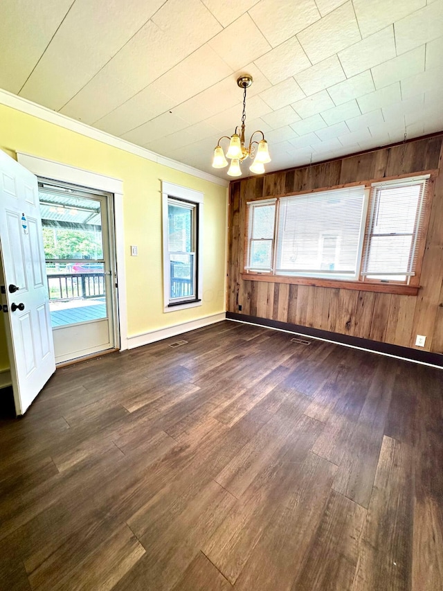 619 Sugar St, Marion, OH 43302 - unfurnished dining area featuring a chandelier, dark wood finished floors, wood walls, ornamental molding, and baseboards