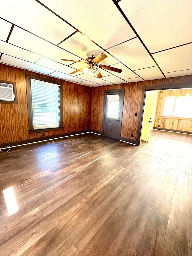 619 Sugar St, Marion, OH 43302 - unfurnished living room with wood walls, a ceiling fan, wood finished floors, a wall mounted AC, and baseboards