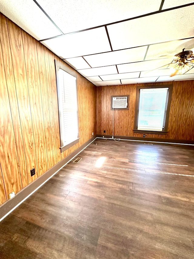 619 Sugar St, Marion, OH 43302 - empty room featuring wood finished floors, an AC wall unit, wooden walls, a ceiling fan, and a drop ceiling