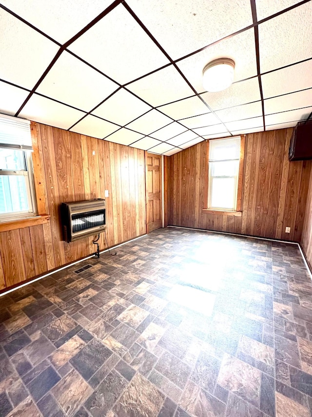 619 Sugar St, Marion, OH 43302 - unfurnished living room featuring wood walls, heating unit, baseboards, and a paneled ceiling