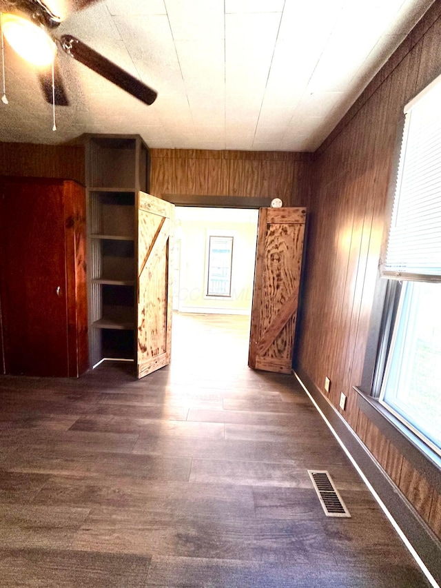 619 Sugar St, Marion, OH 43302 - unfurnished living room with wood walls, dark wood-style flooring, and ceiling fan