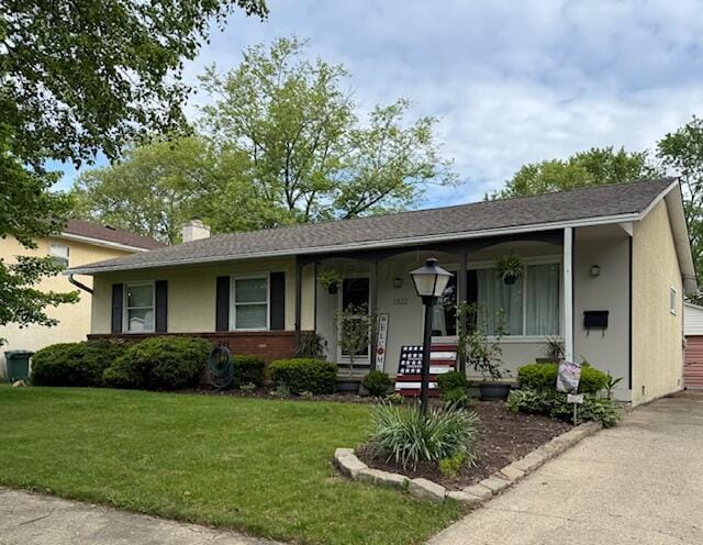 ranch-style house with a front lawn, a chimney, covered porch, and stucco siding