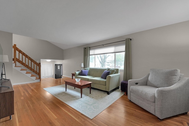 2711 Montcalm Rd, Columbus, OH 43221 - living room with stairs, vaulted ceiling, light wood-type flooring, and baseboards