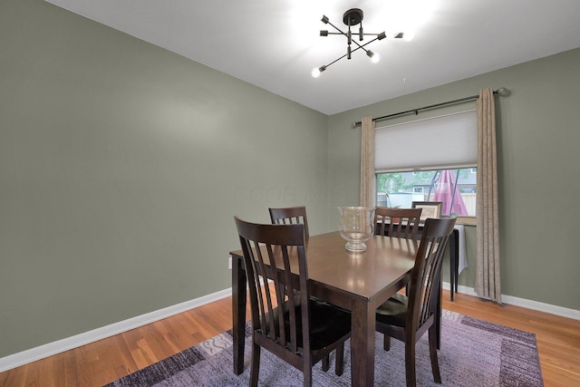 2711 Montcalm Rd, Columbus, OH 43221 - dining room featuring a chandelier, wood finished floors, and baseboards