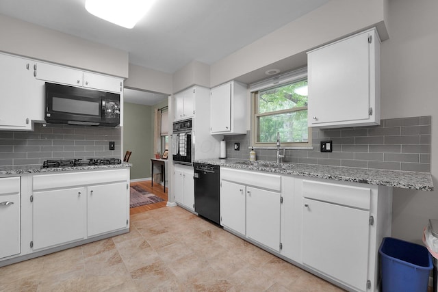2711 Montcalm Rd, Columbus, OH 43221 - kitchen featuring black appliances, a sink, white cabinetry, decorative backsplash, and light stone counters