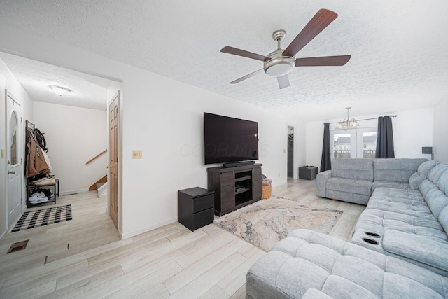 5039 Lee Rd, South Bloomfield, OH 43103 - living area featuring a textured ceiling, light wood-style floors, ceiling fan, stairway, and a chandelier
