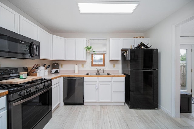 5039 Lee Rd, South Bloomfield, OH 43103 - kitchen with black appliances, a sink, light countertops, and white cabinets