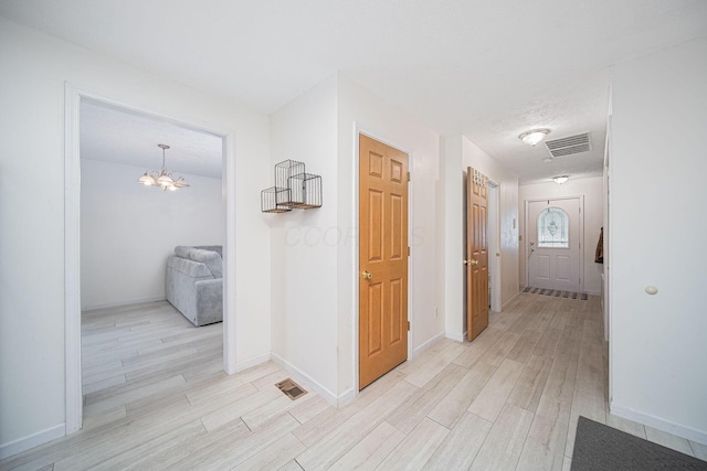 5039 Lee Rd, South Bloomfield, OH 43103 - corridor with light wood-type flooring, a chandelier, and baseboards