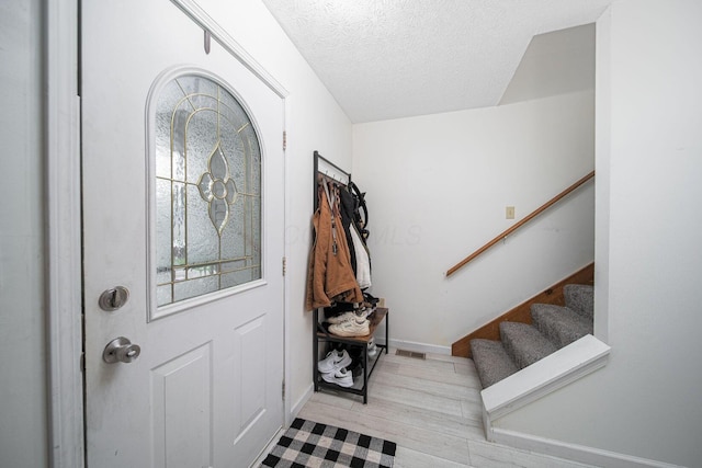 5039 Lee Rd, South Bloomfield, OH 43103 - entryway featuring wood finished floors, stairs, a textured ceiling, and baseboards