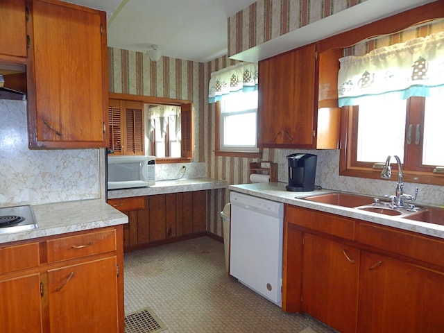 2705 County Road 118, Rushsylvania, OH 43347 - kitchen with white appliances, wallpapered walls, light countertops, a sink, and brown cabinets