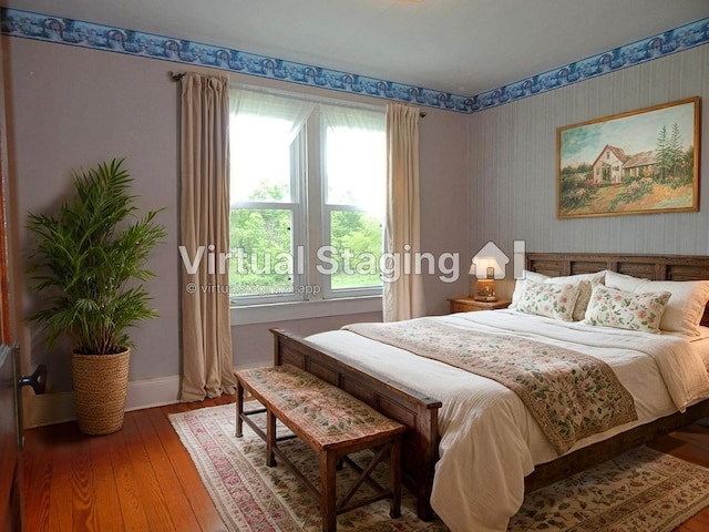 2705 County Road 118, Rushsylvania, OH 43347 - bedroom featuring multiple windows, wallpapered walls, hardwood / wood-style flooring, and baseboards
