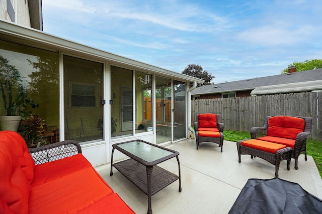view of patio featuring fence and a sunroom