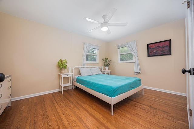 bedroom featuring wood finished floors, baseboards, and ceiling fan