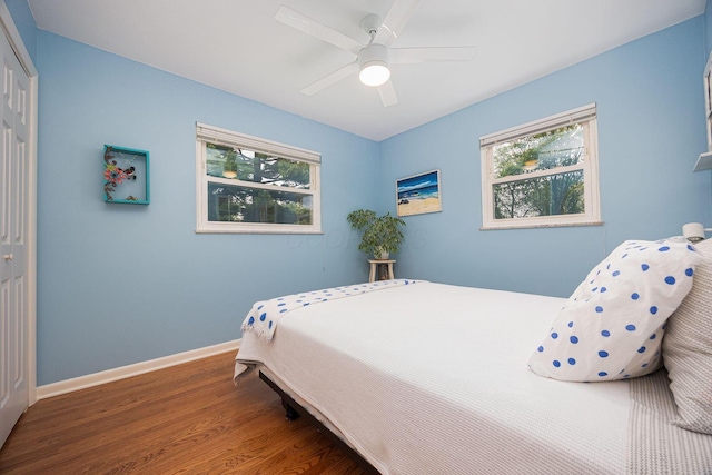 bedroom featuring wood finished floors, a closet, baseboards, and a ceiling fan