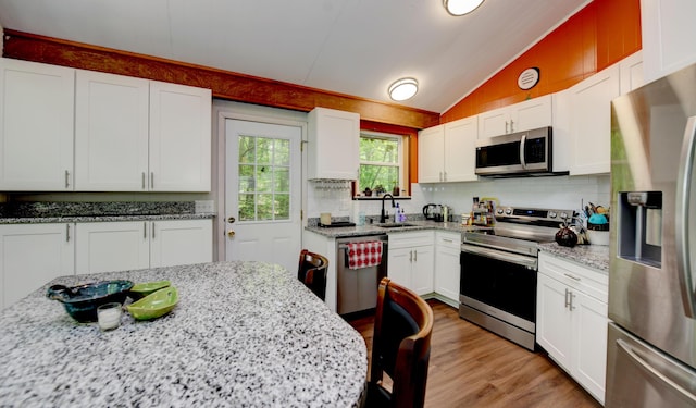 1160 Flathead Ln, Sugar Grove, OH 43155 - kitchen featuring stainless steel appliances, vaulted ceiling, white cabinetry, backsplash, and light wood finished floors