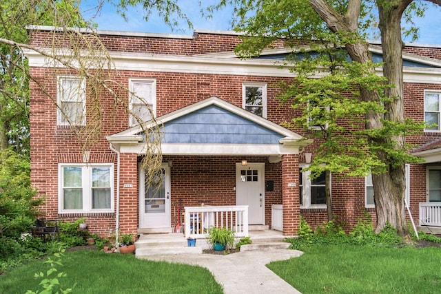 1369 Meadow Rd, Columbus, OH 43212 - view of front of home with brick siding, a porch, and a front yard