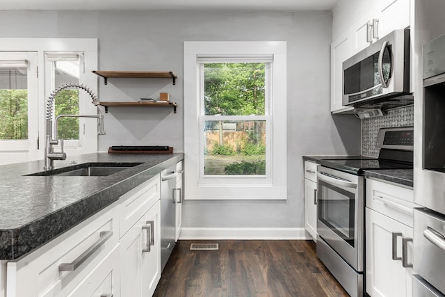 1369 Meadow Rd, Columbus, OH 43212 - kitchen featuring stainless steel appliances, a sink, dark wood-type flooring, and dark stone countertops