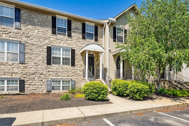 view of front of home with uncovered parking and stone siding