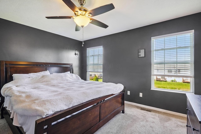 bedroom with baseboards, light carpet, and a ceiling fan