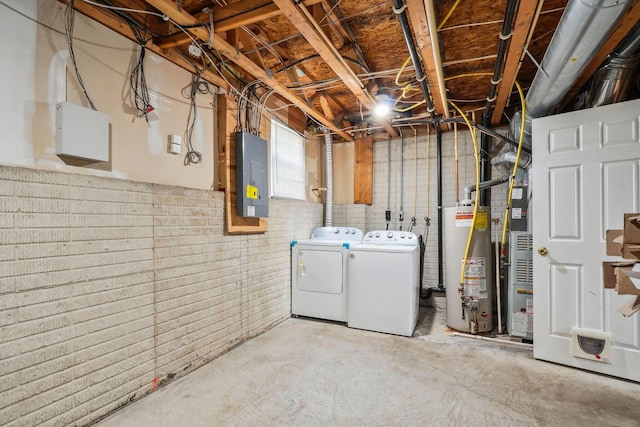 unfinished basement featuring gas water heater, electric panel, and washer and clothes dryer