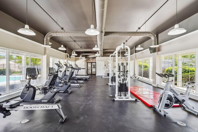 gym featuring healthy amount of natural light and a high ceiling