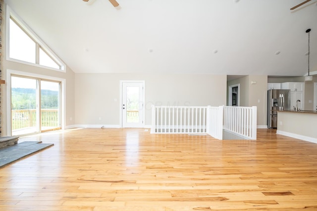 7885 Upper Twin Rd, South Salem, OH 45681 - unfurnished living room with light wood-style floors, high vaulted ceiling, a ceiling fan, baseboards, and a sink