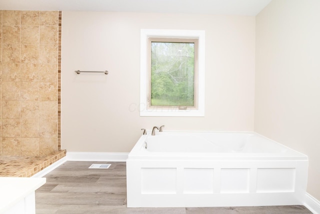 7885 Upper Twin Rd, South Salem, OH 45681 - bathroom with a garden tub, baseboards, wood finished floors, and a tile shower
