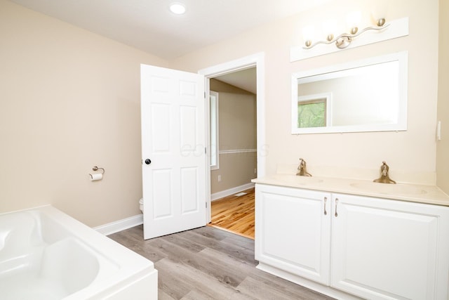 7885 Upper Twin Rd, South Salem, OH 45681 - full bath with wood finished floors, a garden tub, toilet, vanity, and baseboards
