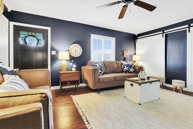 7677 Opossum Run Rd, London, OH 43140 - living room with a barn door, wood finished floors, ceiling fan, and baseboards