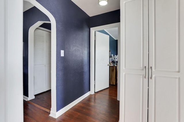 7677 Opossum Run Rd, London, OH 43140 - corridor with wood finished floors, baseboards, a textured wall, and arched walkways
