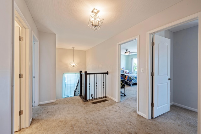 331 Hardwood Ave, Circleville, OH 43113 - hall featuring carpet, an upstairs landing, a chandelier, and baseboards
