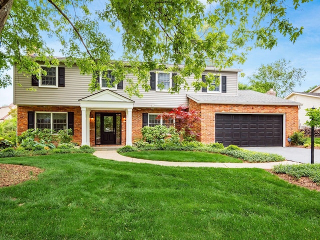 view of front of property with brick siding, a front yard, and driveway