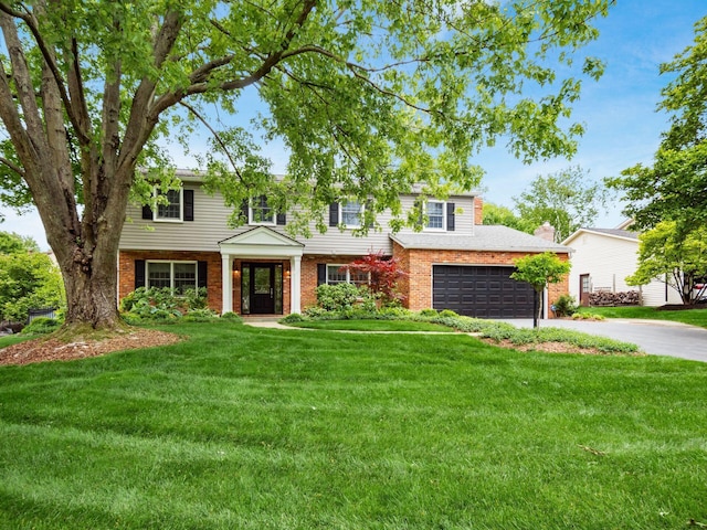 view of front facade featuring asphalt driveway, brick siding, and a front lawn